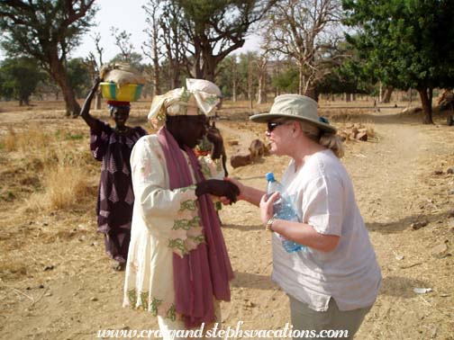 Tina is greeted by a village woman