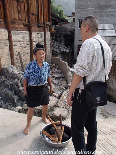 Wang Jun speaks with a Small Horn Miao woman in Shi Qing Village
