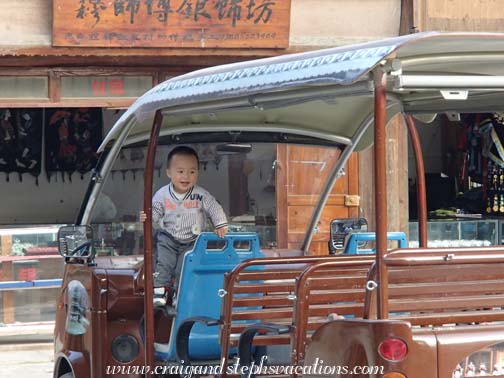Little boy plays in a golf cart