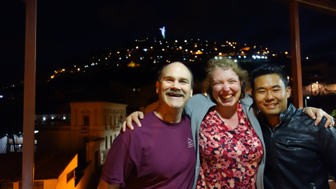 Craig, Steph, and Sonam at Leña Quiteña with the Virgin of Quito in the background