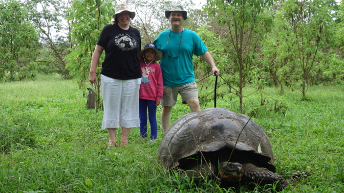 Achi Mama, Sisa, and Achi Taita with a giant tortoise