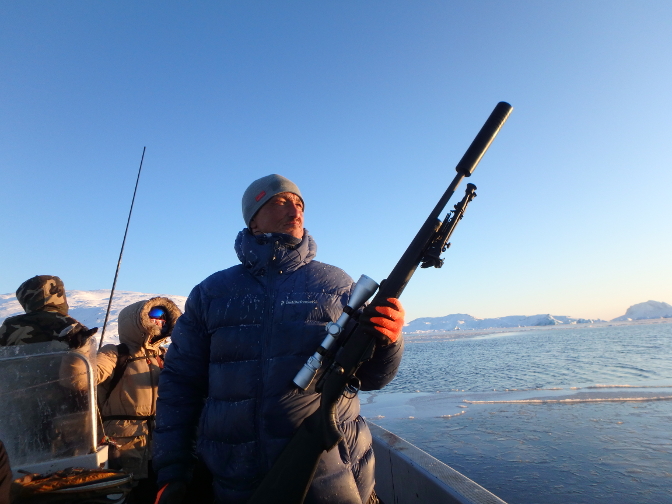 Mikael prepares his rifle for the seal hunt