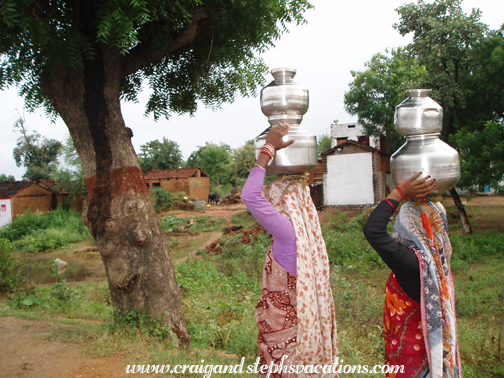 Locals carry urns on their heads