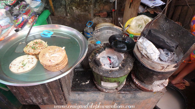 Burmese pancakes cooking over wood coals, Hledan market