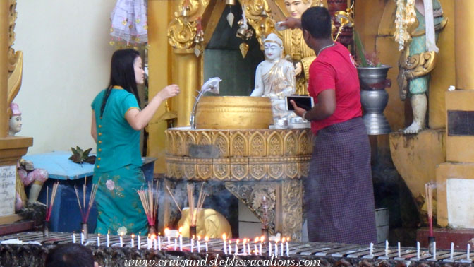 Worshippers wash a statue at the bo bo gyi (planetary post) corresponding to the day of the week of their birth