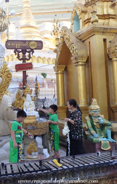 Worshippers wash a statue at the bo bo gyi (planetary post) corresponding to the day of the week of their birth