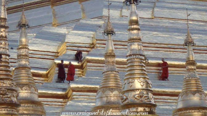 Monks walk on the octagonal ridges of Shwedagon Pagoda looking for gems displaced by birds