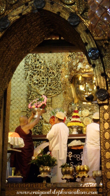 Monk presents offerings to Mahamuni Buddha