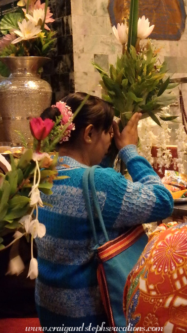 Woman offers flowers to the Mahamuni Buddha