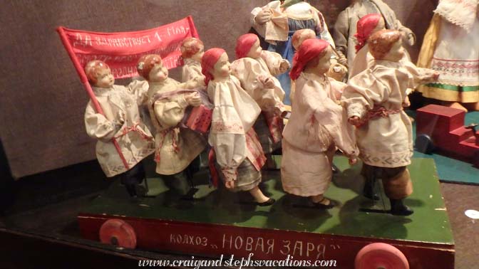 Soviet toy: collective farmers on parade. 'We glorify the 1st of May.' When it is pulled, the farmers march.