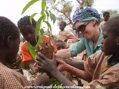 Susan plants a tree with the students