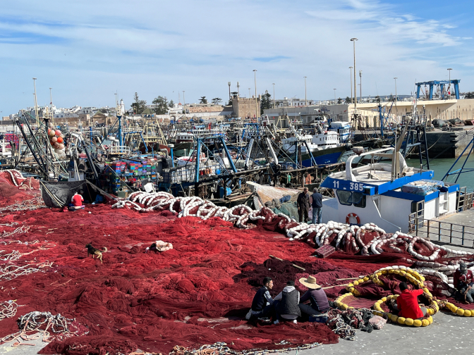 Fishermen mending their nets at the port