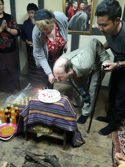 Preparing to cut the cake while Craig blows out the candles