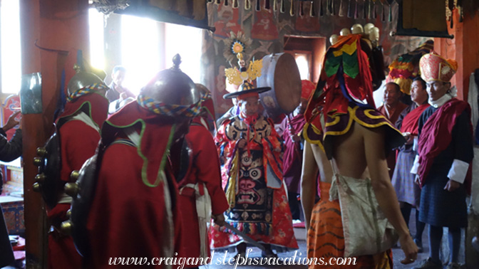 Lama (center), musicans, and masked dancers in the lhakhang