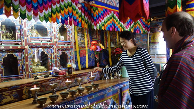 Tshering lights a butter lamp at the family altar