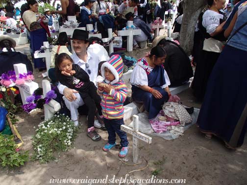 The family eats with their community at the cemetery