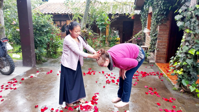 Sisa puts rose petals on Achi Mama's head for Pawkar Raymi