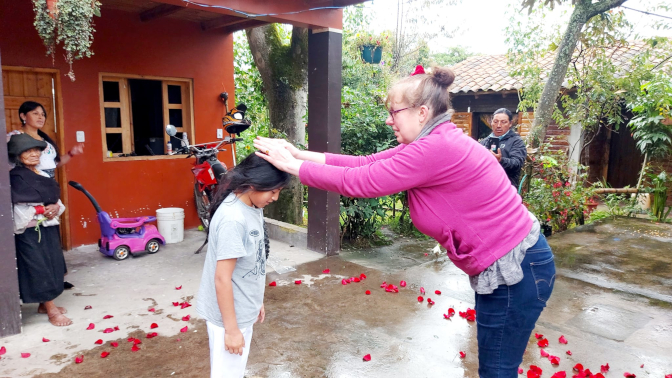 Achi Mama puts rose petals on Yupanqui's head for Pawkar Raymi