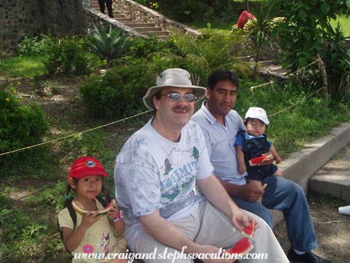 Aracely, Craig, Humberto, and Eddy enjoy watermelon by the lake