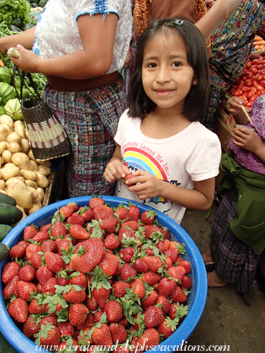 Aracely looks at the strawberries at the market