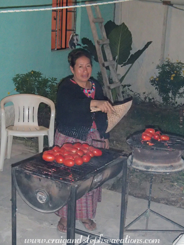 Estela fans the coals on the grills