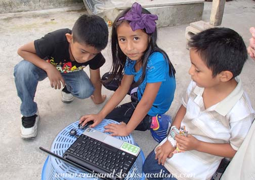 Josue, Aracely, and Eddy play with the netbook