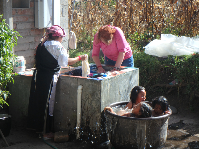 Rosa and Steph doing laundry while the kids bathe