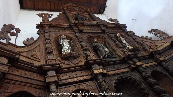 Elaborately carved wooden altar, combining Mayan and Catholic imagery