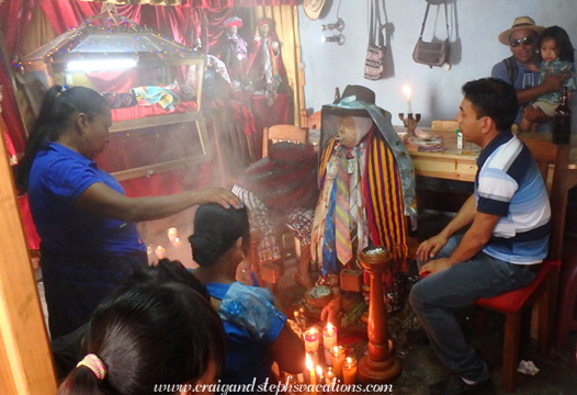 A Mayan Ajq'ij (spiritual guide) performs a ritual in front of Maximon