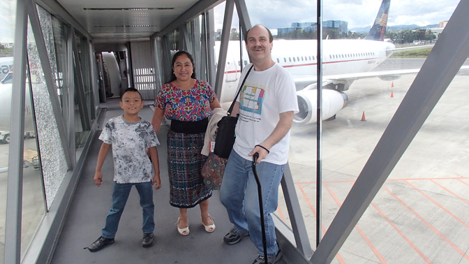 Eddy, Paulina, and Craig on te jet bridge, preparing to board their first flight