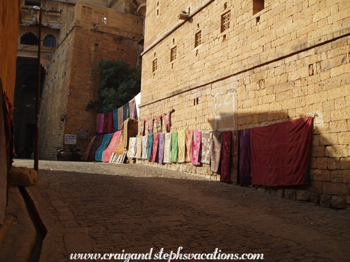 Textiles for sale in a Jaisalmer alleyway