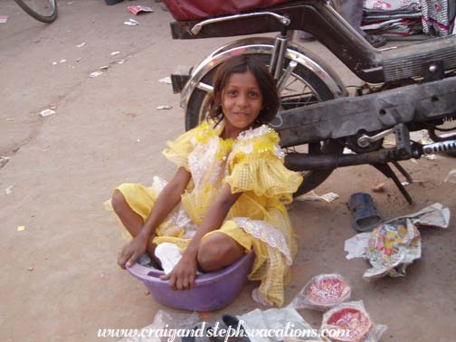 Little girl sitting in a plastic bowl, Sardar Market Girdikot, Jodhpur