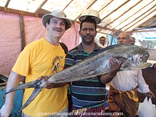 Fisherman photobombs his friend by giving him a colander as a hat