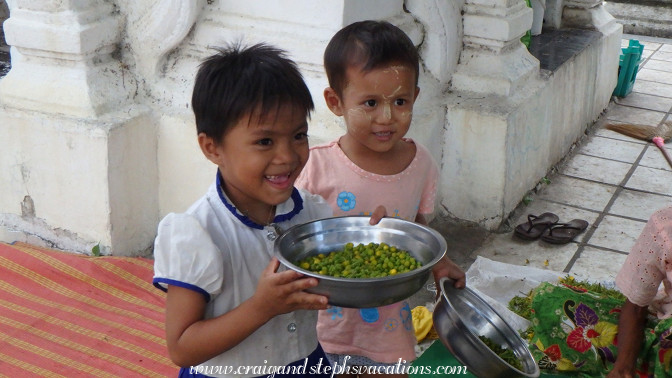 Little girls helping their mom to peel produce