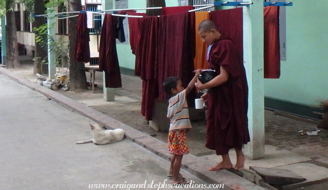 Monk gives a young boy a pencil and notebook