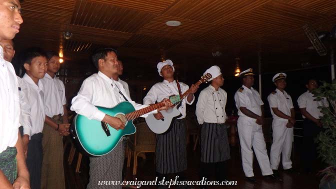 Win and the baker play guitar while the crew sings traditional songs for us