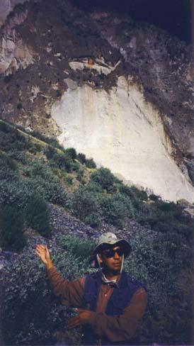 Carlos pointing out hanging tombs in the mountainside