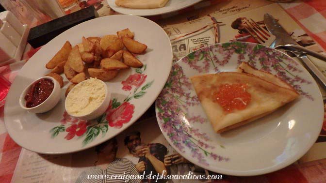 country style potatoes with adjika and cheese sauce (French fries with processed cheese and Georgian spicy sauce) and pancakes with red caviar (salmon)